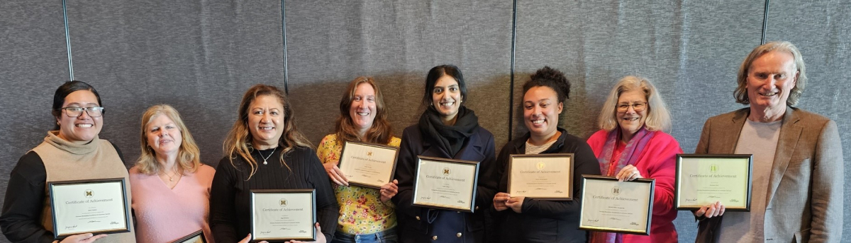 A photo of a group of people holding certificates after graduating Dale Carnegie